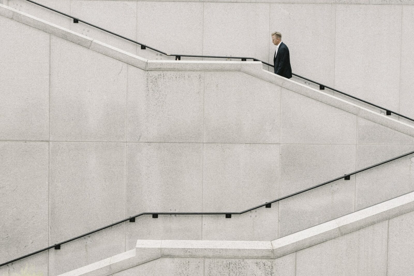 Person walking up a long concrete staircase